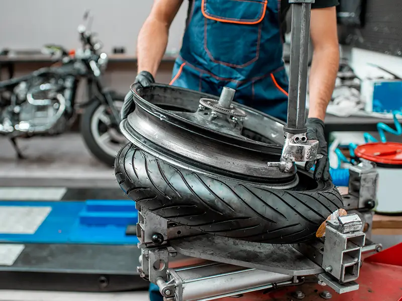 Montage d’un pneu moto en atelier chez Bomerée Pneus à Montigny-le-Tilleul.