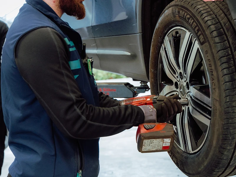 Serrage d’une roue avec outil électrique après permutation des pneus.