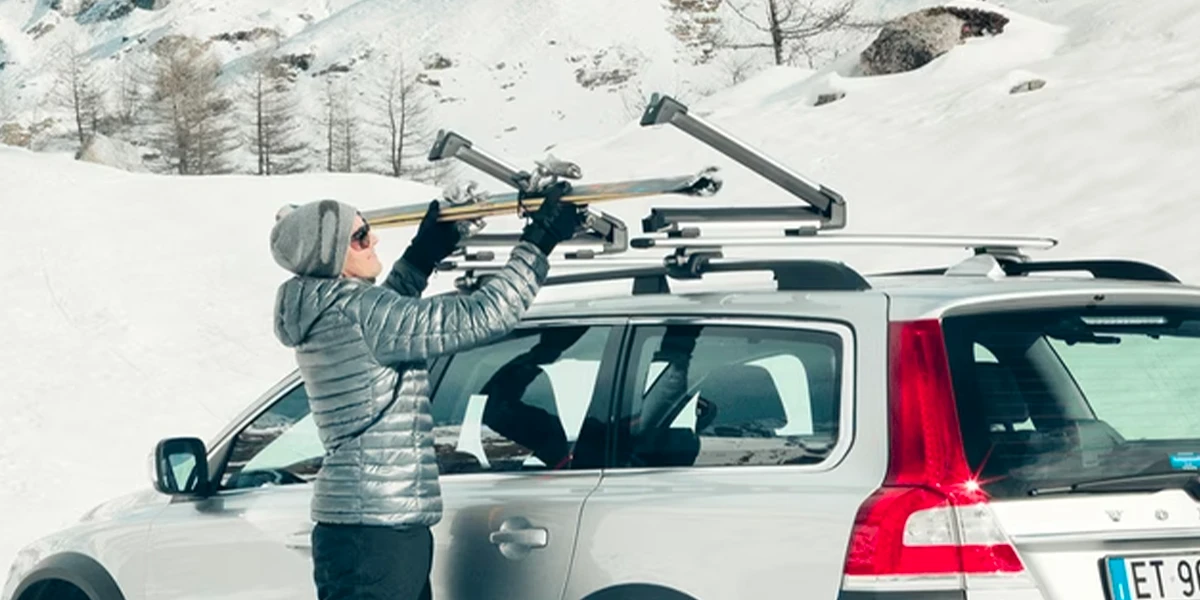 Porte-skis installé sur le toit d’une voiture pour transporter des skis vers la montagne.